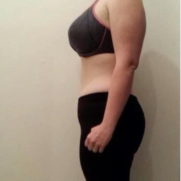 Person wearing a black sports bra and feeling debloated in the background