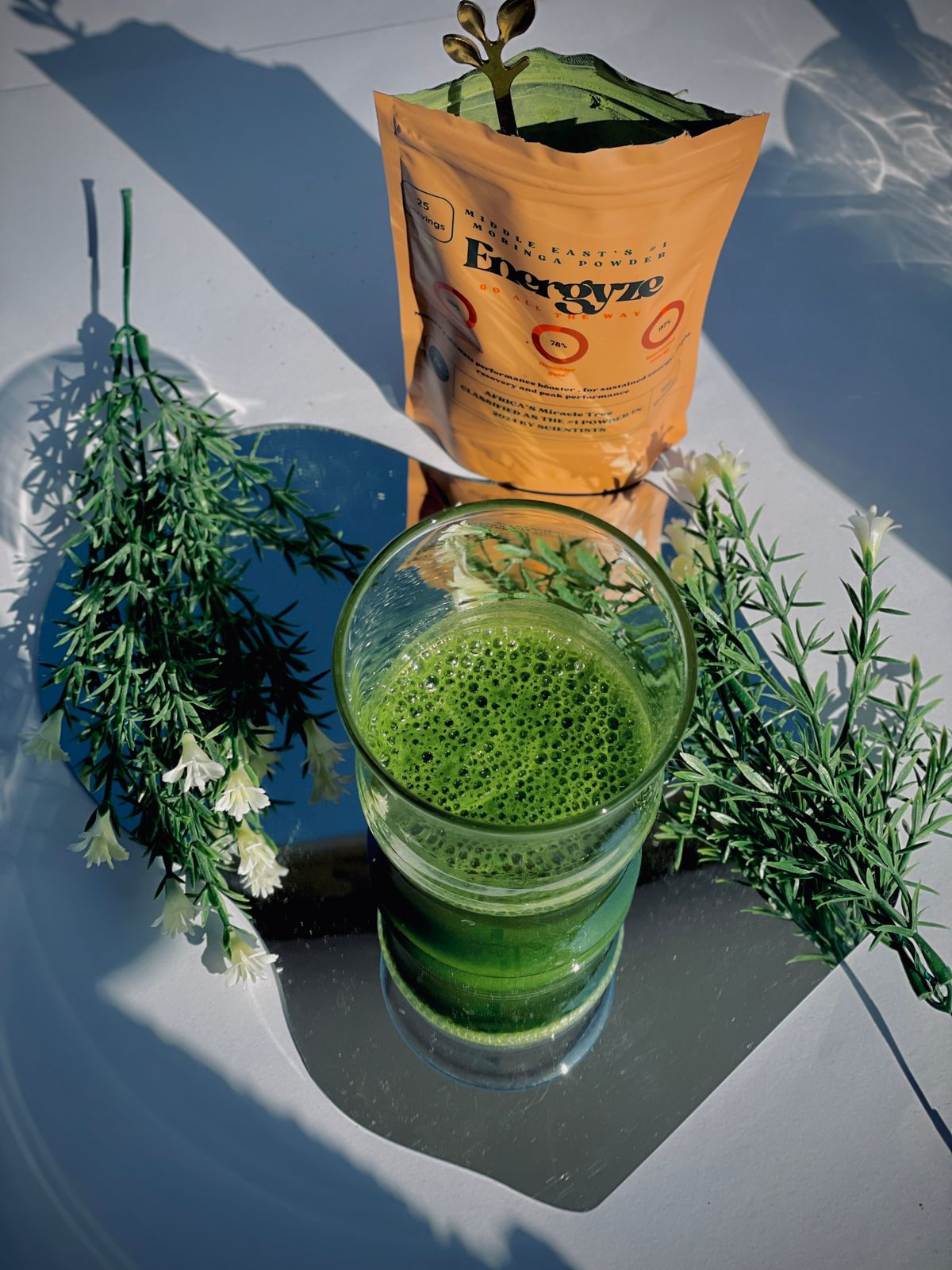 Glass of green juice with a bag of energyze in the green